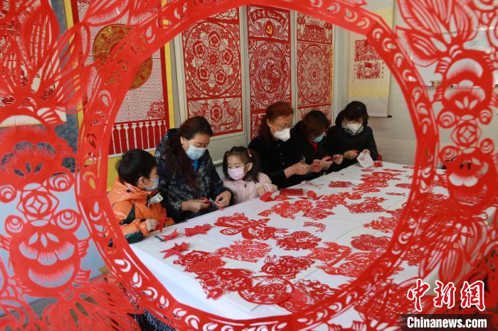 12月30日，在山东省高密市剪纸艺社，非遗传承人和孩子们正在进行迎新年剪纸创作。　李海涛 摄