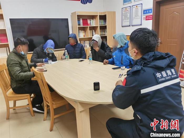 图为海警执法员与获救人员交流。　广西海警局供图