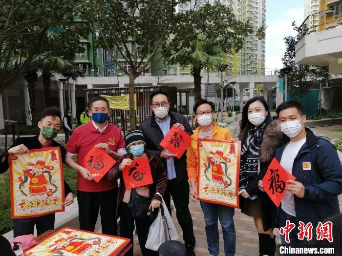 陈百里(左二)与义工一起向市民赠送挥春。　香港菁英会供图