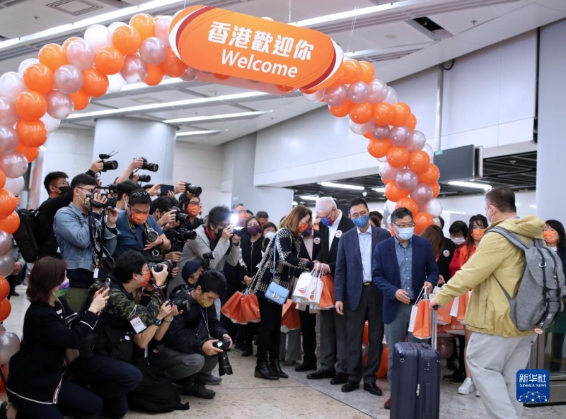 1月15日，在香港的西九龙站，工作人员迎接恢复通车后内地驶往香港首趟列车的旅客并赠送小礼物。新华社记者 李钢 摄