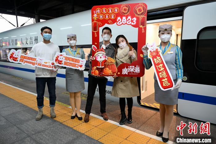 1月15日，广州东开往香港西九龙的首发高铁前，旅客与工作人员开心合影。　陈骥旻 摄