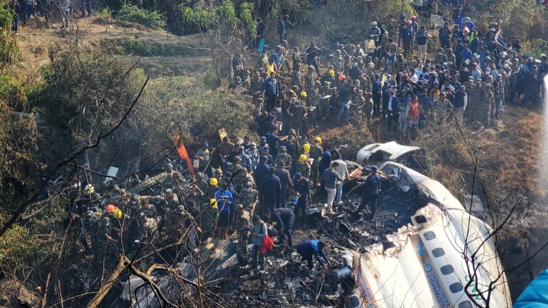 当地时间1月15日，意外发生后，大批人在位于博克拉的空难现场聚集。（图源：路透社）