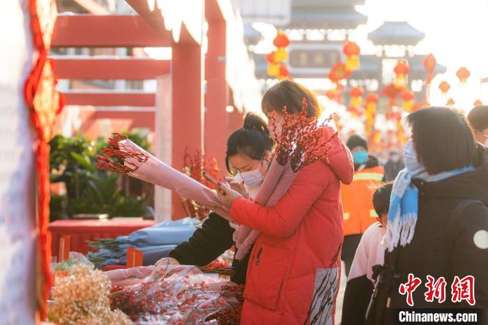 图为市民游客在茅庙集庙会上购买鲜花 徐一帆 摄