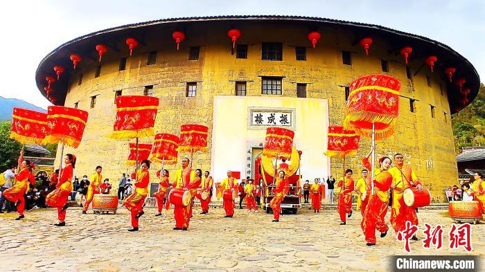 为丰富节日旅游内容，永定土楼景区白天推出了大鼓凉伞舞等非遗项目表演。　永定土楼景区供图