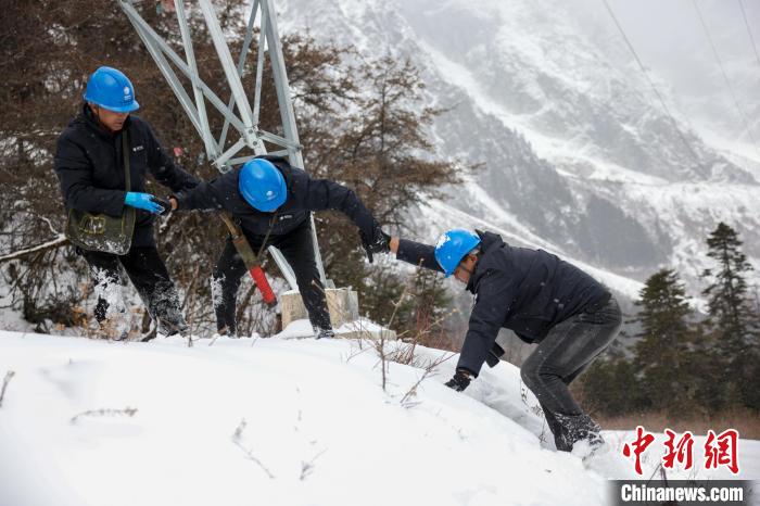 西藏波密县电力巡护人员相互帮助，趟雪踏冰。　李东淮 摄
