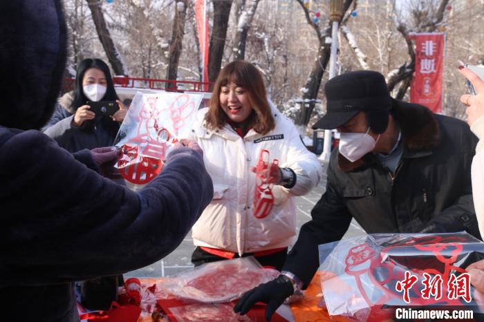 一张张寄托着美好祝愿的剪纸送给市民。　潘琦 摄