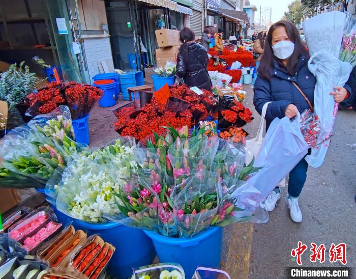 图为民众购得鲜花满怀。　杨英琦 摄