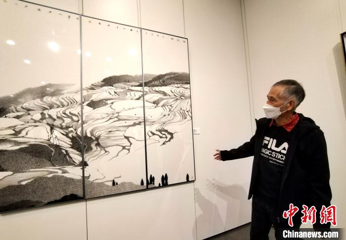 香港著名画家黄孝逵介绍其画作。　索有为 摄