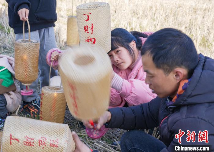 圖為村民在採集點用火種點亮燈籠。　張淩欣 攝