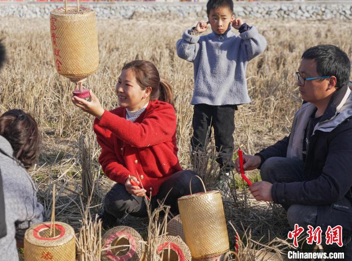 圖為村民在採集點用火種點亮燈籠。　張淩欣 攝