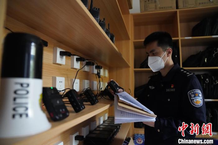 图为民警黄昊正在清点整理执法记录仪。　王荣鑫 摄