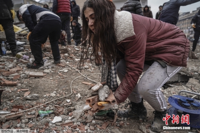 当地时间2月6日，土耳其加济安泰普，民众在震后自发参与救援行动，他们在坍塌的废墟中徒手搬运碎石，寻找被困幸存者。