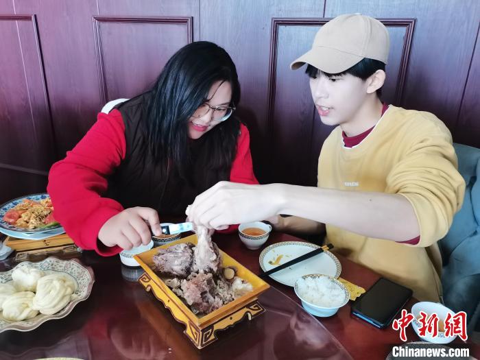 图为内蒙古大学学生朱拉(左一)在为台胞青年丘秉儒(右一)科普饮食文化。　傅雅鑫 摄