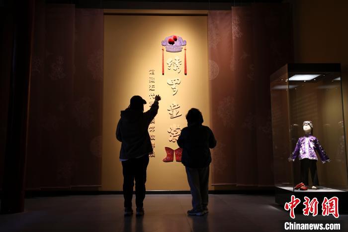 山西太原，民众正在参观《绣罗童裳——馆藏近代童衣装饰纹样展》。　张云 摄