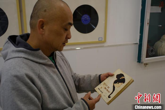 图为江波正在展示自己收藏的与黄婉秋有关的书籍。　刘俊聪 摄