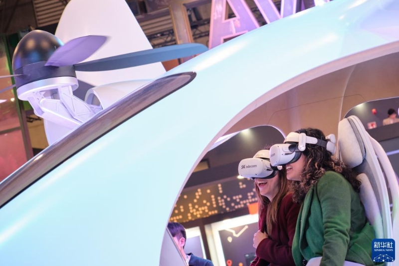 2月27日，参观者在西班牙巴塞罗那举行的世界移动通信大会上体验虚拟现实眼镜。（图源：新华社）