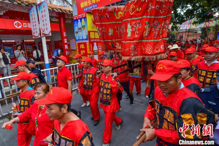 图为众人抬着冼夫人的“神舆”，走在“装军巡游”队伍中。　骆云飞 摄