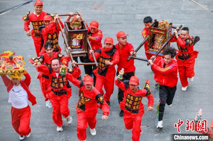 图为活动中民众抬着“神舆”冲向“点将台”。　骆云飞 摄