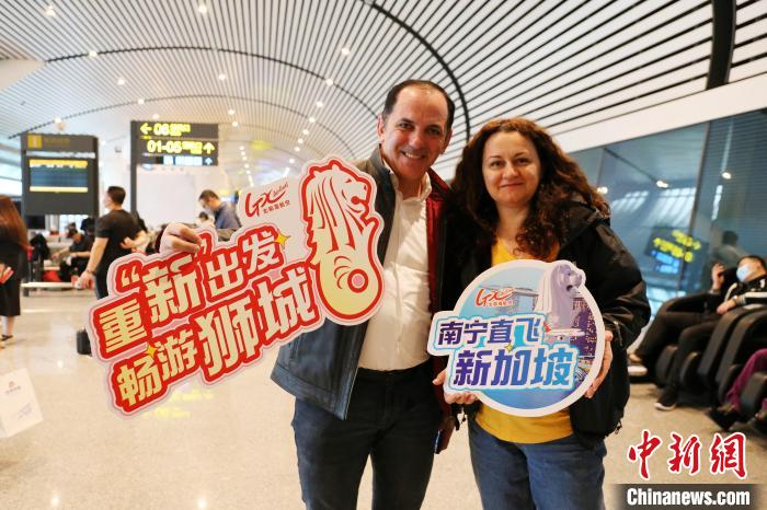 图为乘坐南宁至新加坡航班的外籍旅客拍照留念。　黄秉柱 摄