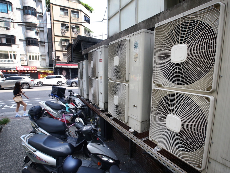 台湾第二核能发电厂2号机14日期满除役，外界担心影响供电。图为一位民众走过成排的冷气室外机。（图源：台湾“中时新闻网”）