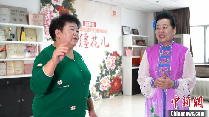 王秀芳一边唱一边向跟她学习“新疆花儿”的爱好者讲解歌词的含义 戎睿 摄