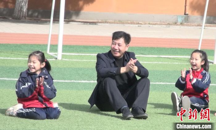 图为“校长爷爷”在操场上与学生们做游戏。　陈峰 摄