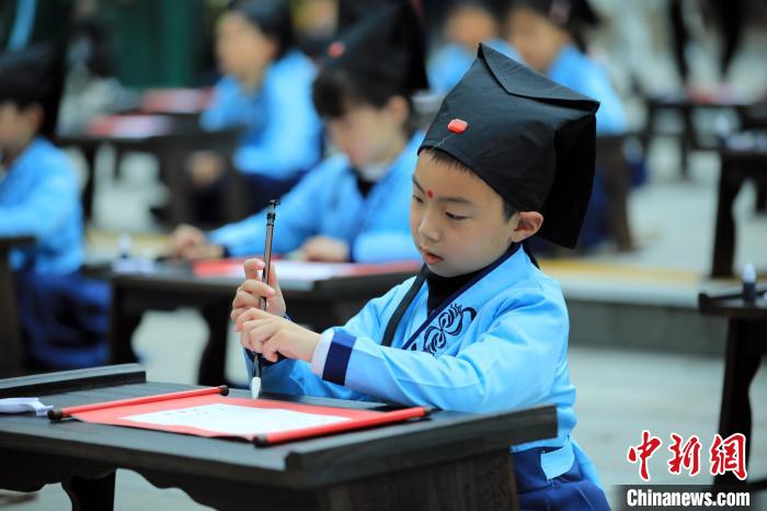 小朋友在老师的指导下开笔描红，学写“人”字。　汤彦俊 摄