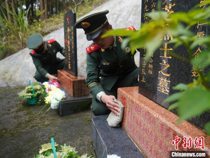 武警官兵为烈士擦去碑前尘土。　蒋苏昇 摄