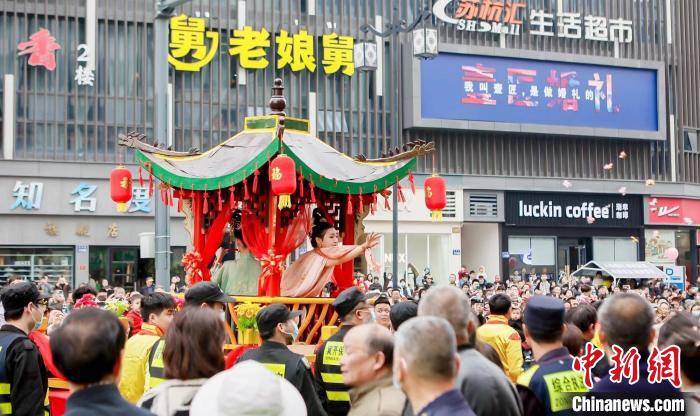 蚕花姑娘将寓意祝福的蚕花、糖果抛向民众 新市镇供图