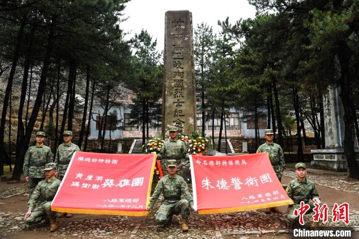 “黄崖洞保卫战英雄团”战旗和“朱德警卫团”战旗在黄崖洞保卫战殉国烈士纪念塔前展开。　黄崖洞革命纪念地供图