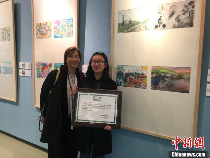 4月9日，“大湾区孩子们心目中的碳中和世界”绘画作品展开幕。图为香港青少年莫凯荧(右)与妈妈合影。　陈建新 摄