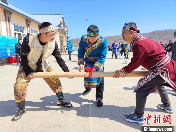 赫哲族人展示趣味体育活动“顶杠”。　姜辉 摄