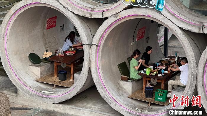 图为顾客在水泥管道内用餐。　肖江川 摄