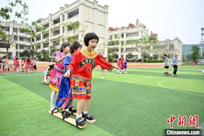 学生身着民族服饰玩三人板鞋。　俞靖 摄