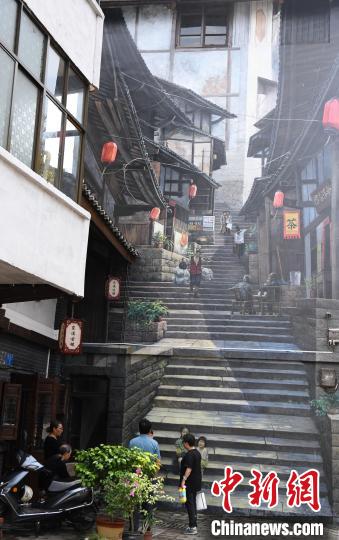 东溪古镇内的巨型壁画与现实生活场景交相呼应。　周毅 摄