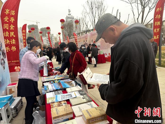 图为民众在活动现场读书、购书。　李隽 摄