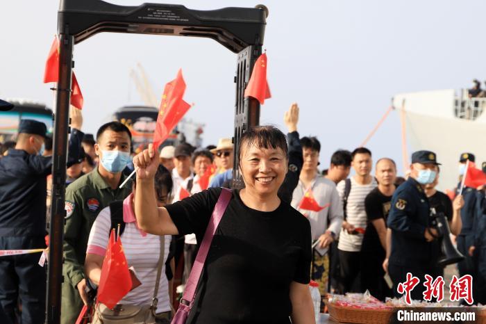 当地时间4月26日，海军军舰赴苏丹紧急撤离我在苏丹人员。图为撤离人员通过安检后挥舞五星红旗。　吴亢慈 摄