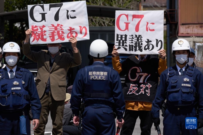 4月16日，在日本长野县轻井泽车站附近，抗议者手举标语抗议。（图源：新华社）