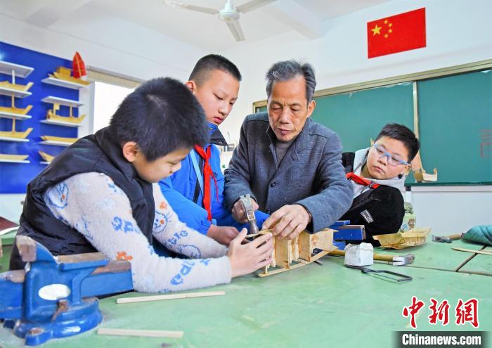 国家级非物质文化传承人刘细秀(右二)在指导孩子们制作福船船模。　褚子强 供图