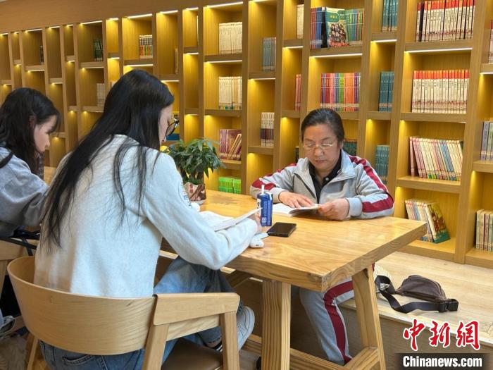 图为22日，左桂香(右一)在新建区抱朴书屋阅读。　朱莹 摄