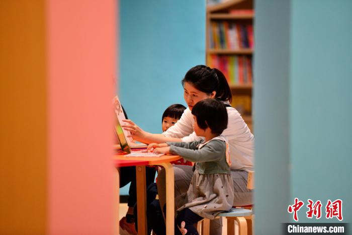 图为家长带着小孩在福州安泰新华书店阅读。　张斌 摄