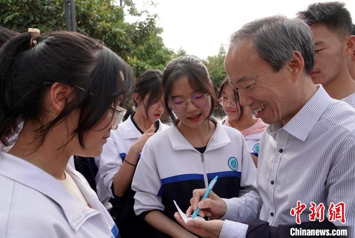 论坛闭幕后，王心源研究员应邀参访腾冲第一中学与学生代表座谈交流，为学生签名寄语。　<a target='_blank' href='/'>中新社</a>记者 孙自法 摄