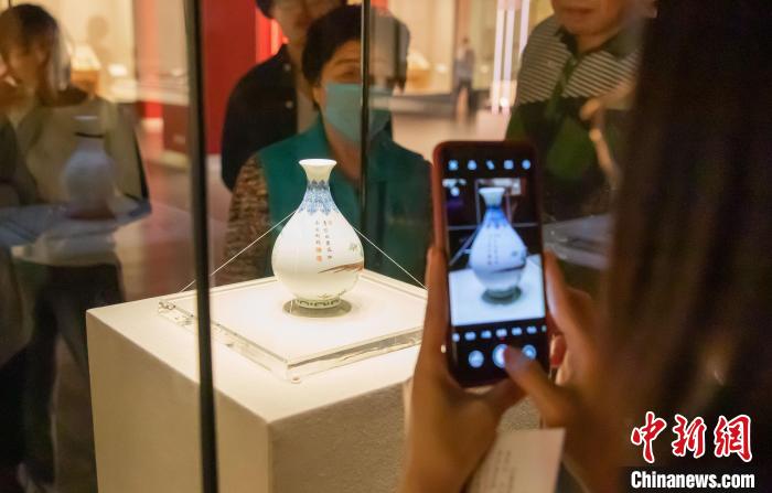 游客正在观看天津博物馆“镇馆之宝”清乾隆款珐琅彩芍药雉鸡图玉壶春瓶。　王在御 摄