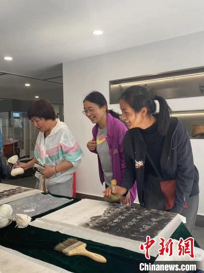 图为观展者体验传拓技艺。　云南大学伍马瑶人类学博物馆供图