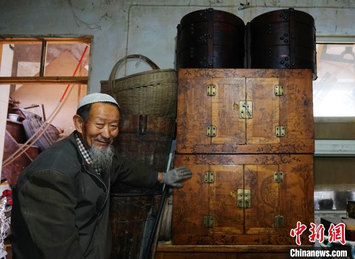 图为收藏爱好者马斌成介绍自己收藏的老门箱。　马铭言 摄