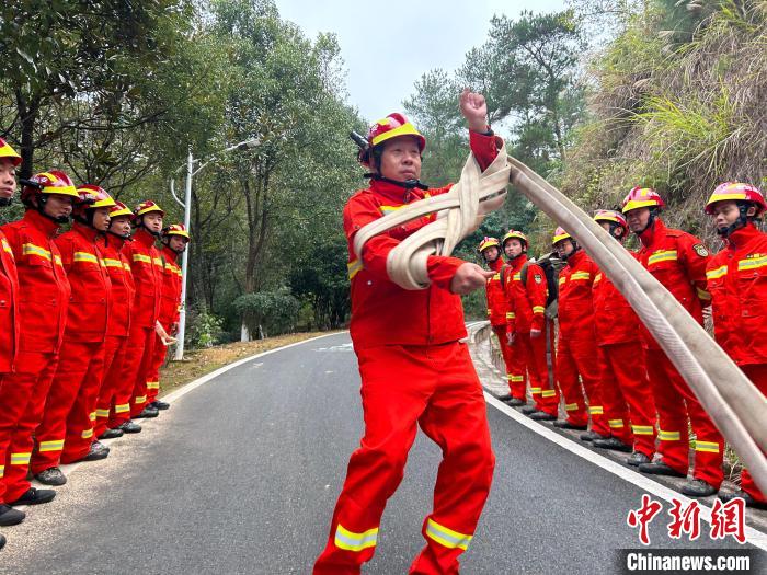 钟晓金正在向队员们展示如何快速回收消防水带。　杜南音 摄