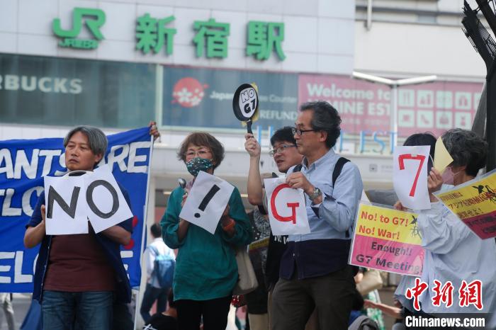 5月21日，日本民众手举标语，在东京新宿车站附近举行集会，强烈抗议G7广岛峰会。　蒋文月 摄