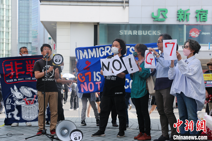 5月21日，日本民众手举标语，在东京新宿车站附近举行集会，强烈抗议G7广岛峰会。 中新社发 蒋文月 摄