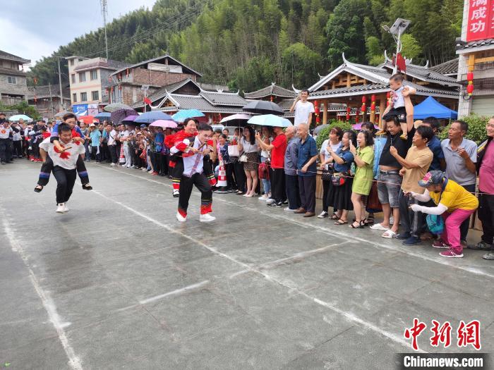 5月26日，在广西龙胜各族自治县马堤乡，当地苗族民众进行“背媳妇”比赛。　韦吉阳 摄