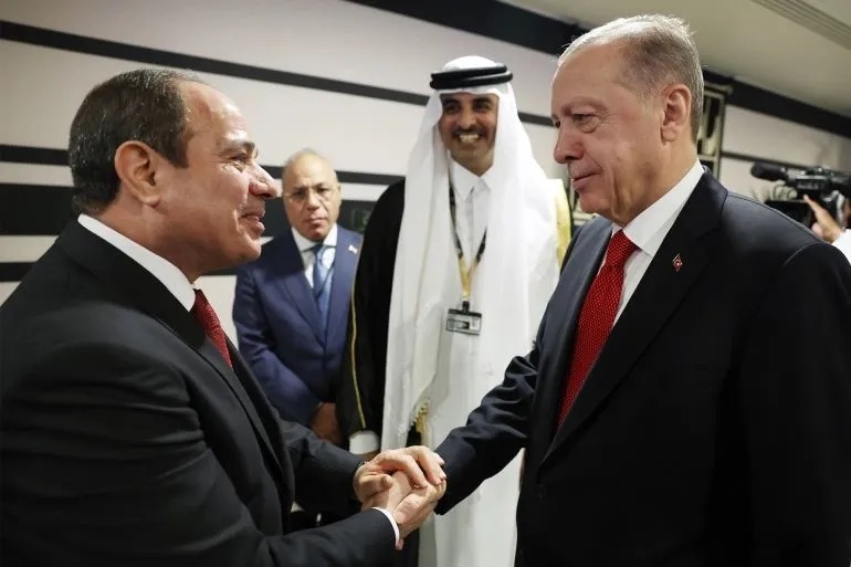 土耳其总统埃尔多安（右）在卡塔尔世界杯决赛开幕式上与埃及总统塞西抓手。 （图源：阿纳多卢通信社）